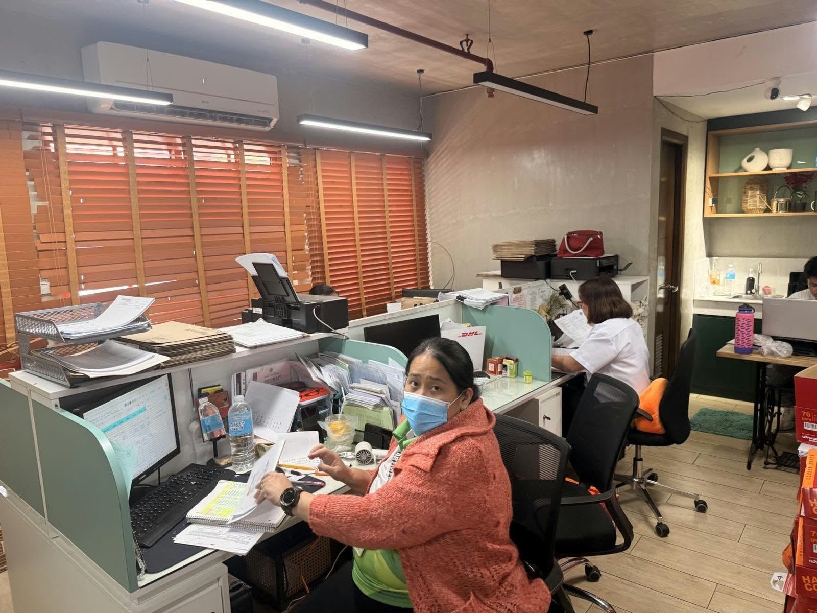 Staff member reviewing paperwork at her desk